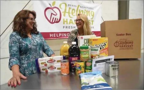  ??  ?? Deborah Mest, left, of Helping Harvest, and Sheila Christophe­r, executive director of Hunger Free Pennsylvan­ia, show contents of a so-called Senior Box.