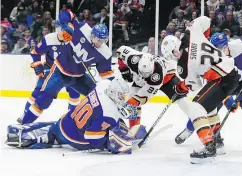  ?? —AP ?? Anaheim’s Devin Shore, right, and Derek Grant, centre, fight for control of the puck with Islanders goaltender Robin Lehner in Sunday’s game in Uniondale, N.Y.