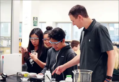  ?? NEWS PHOTO EMMA BENNETT ?? John Laing works with students Crystalene Girao, White Snow, Joan Sumalague during a Chemistry 20 class at Medicine Hat High School on Thursday.