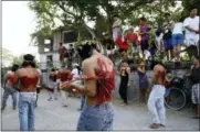  ?? THE ASSOCIATED PRESS ?? Residents watch as Filipino hooded penitents flagellate during Good Friday rituals to atone for sins in San Fernando, Philippine­s, on Friday.