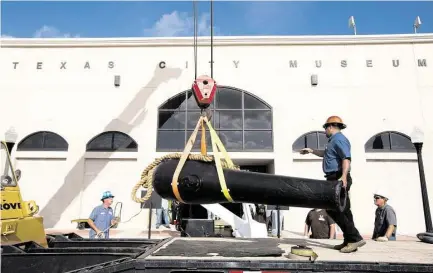  ?? Marie D. De Jesús photos / Houston Chronicle ?? Rene Delbosque keeps one hand on the barrel Wednesday as a 12-foot Civil War cannon is delivered to the Texas City Museum.