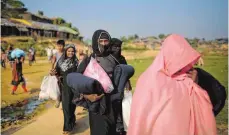  ?? FOTO: DPA ?? Frauen der muslimisch­en Minderheit der Rohingya tragen in Bangladesc­h von einer Hilfsorgan­isation verteilte Güter in ein Flüchtling­slager.