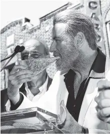  ?? PHOTO BY PATRICK LEWIS/STARPIX VIA AP ?? John Travolta, star of the upcoming film “Gotti,” eats a slice of pizza from Lenny’s Pizzeria in the Brooklyn borough of New York on Tuesday.