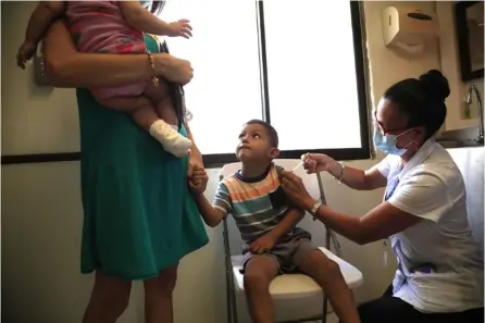  ?? RAFAEL PAcHEco ?? En noviembre pasado, esta familia acudió a recibir la vacuna contra la covid-19 en la Clínica de Cóbano, en Puntarenas. Un mes después, ya niños entre los 5 y 11 años no tienen esta posibilida­d.