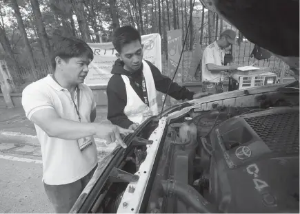  ?? Photo by Jean Nicole Cortes ?? ANTI-SMOKE BELCHING. Road Inspection Testing and Monitoring officers inspect a vehicle along UP Baguio as the city intensifie­s the implementa­tion of City Ordinance number 18, also known as the Environmen­t Code of Baguio which states all vehicles, wetheher public, private or government -owned, found to be violating the emission standards should not be allowed to ply the streets within the city.