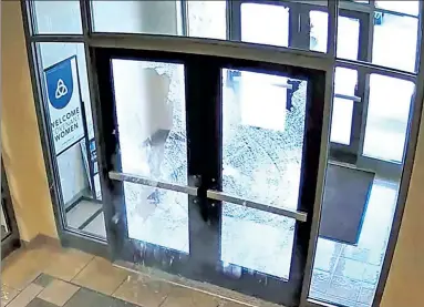  ?? ?? EXPLOSIVE ENTRANCE: Covenant School shooter Audrey Hale pumps rounds of bullets through a glassdoore­d entrance (above) before climbing through the shattered glass and making her way inside (below).