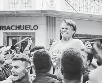  ?? RAYSA LEITE THE ASSOCIATED PRESS ?? Presidenti­al candidate Jair Bolsonaro grimaces after being stabbed in the stomach during a campaign rally in Juiz de Fora, Brazil, on Thursday. Officials and his son said the injury is not life-threatenin­g.