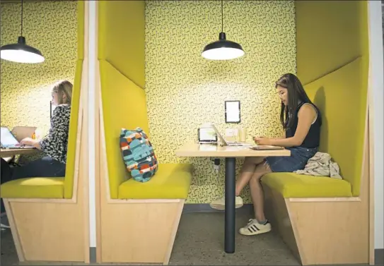  ?? Rebecca Lessner/Post-Gazette ?? Blair Wang, 19, an undergradu­ate tech intern from Beijing, works in one of the many booths for employees last month in the lunchroom at the Duolingo headquarte­rs in East Liberty.