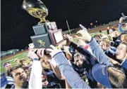  ??  ?? Heritage Hall celebrates with the gold ball championsh­ip trophy Friday after the Class 4A state championsh­ip high school football game between Heritage Hall and Ada at Bill Jensen Field in Choctaw. Heritage Hall won 14-0.