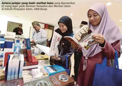 ?? [FOTO SAIFULLIZA­N TAMADI /BH] ?? Antara pelajar yang hadir melihat buku yang dipamerkan di ruang legar pada Seminar Tamadun dan Warisan Islam di Fakulti Pengajian Islam, UKM Bangi.