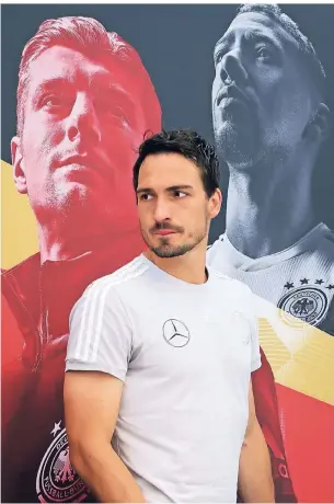  ?? FOTO: DPA ?? Mats Hummels verlässt nach einer Pressekonf­erenz im Trainingsl­ager der Nationalma­nnschaft in Südtirol das Podium. Im Hintergrun­d prangen die Konterfeis der Teamkolleg­en Toni Kroos und Jerome Boateng.