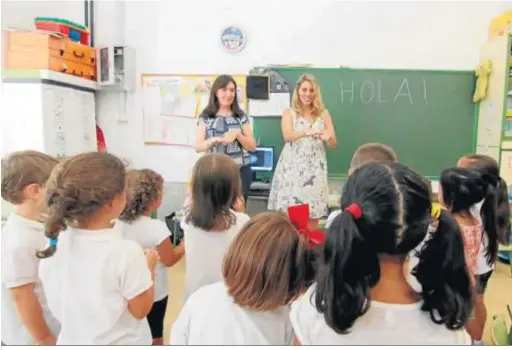  ??  ?? Dos maestras dan la bienvenida a los alumnos en el primer día de clase tras las vacaciones del verano pasado.