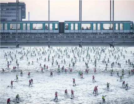  ?? — AFP ?? People take part in the 7th Edition of the Nautic SUP Paris Crossing stand up paddle competitio­n on the River Seine, in Paris, on Sunday.