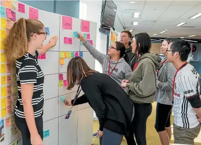  ??  ?? A ‘‘squad’’ of Vodafone staff members in Auckland work together after the introducti­on of Agile, a project-based system of working in small teams.