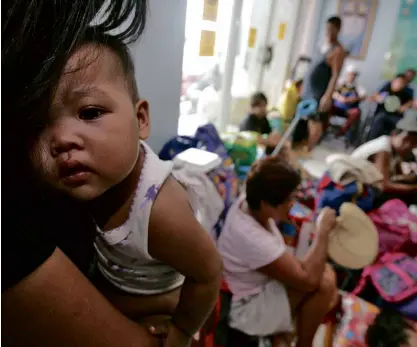  ??  ?? STRANDED Ten-month-old Andrea Marie Tumagan and her mother are among hundreds of Catanduane­sbound boat passengers who are stranded at the port of Tabaco City in Albay.