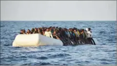  ?? ANDREAS SOLARO/AFP ?? Migrants and refugees sit on a rubber boat before being rescued by the
run by Maltese NGO Moas and Italian Red Cross, off the Libyan coast on November 3.