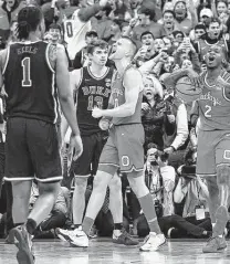  ?? Jay Laprete / Associated Press ?? Ohio State's Justin Ahrens, left, and Cedric Russell celebrate the Buckeyes' come-from-behind victory over Duke.