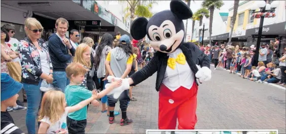  ??  ?? Mickey Mouse is popular with the parade audience.