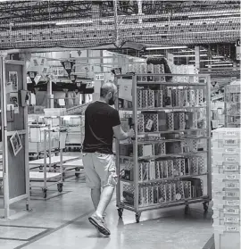  ?? STAFF PHOTO BY DOUG STRICKLAND ?? A worker wheels a shelf of merchandis­e to be packed at the Amazon Fulfillmen­t Center on Aug. 2 in Enterprise South Industrial Park.