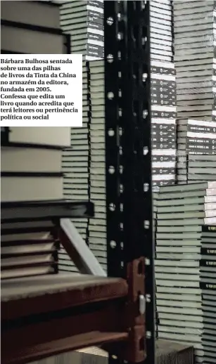  ??  ?? Bárbara Bulhosa sentada sobre uma das pilhas de livros da Tinta da China no armazém da editora, fundada em 2005. Confessa que edita um livro quando acredita que terá leitores ou pertinênci­a política ou social