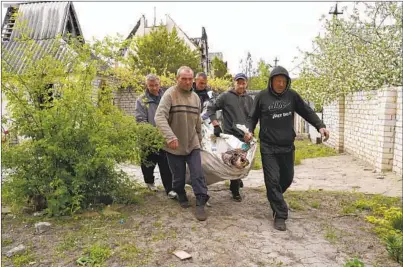  ?? ANDRII MARIENKO AP ?? Volunteers on Wednesday exhume the bodies of civilians killed by Russian shelling in the village of Stepaky, near Kharkiv, Ukraine. The country is examining alleged war crimes committed by Russian forces since the war began in February.