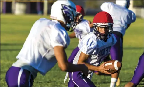  ?? PHOTO VINCENT OSUNA ?? Southwest High quarterbac­k Logan Chell (middle) prepares to hand o the ball to a teammate during a team practice Wednesday afternoon at SHS in El Centro.