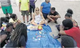  ?? PHOTOS BY JOE CAVARETTA/STAFF PHOTOGRAPH­ER ?? Oakland Park artist Lisa Miceli speaks to children from the Imaginatio­n School of North Lauderdale during a beach cleanup at Fort Lauderdale South Beach Park.