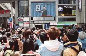  ?? AFP PIC ?? People taking pictures of the announceme­nt of the new imperial era name ‘Reiwa’ in Osaka yesterday.