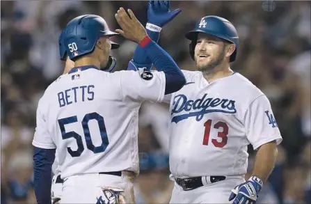  ?? Harry How Getty Images ?? MAX MUNCY (13) enjoys his go-ahead three-run homer with Mookie Betts in the fifth inning as the Dodgers continued their dominance over the Padres with their third straight series win against their division rival. L.A. has a 141⁄2-game lead in the NL West.