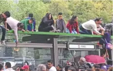  ??  ?? Para apreciar el paso del desfile, muchos de los visitantes se subieron a parabuses, como los que recienteme­nte se colocaron por el Metrobús Reforma.