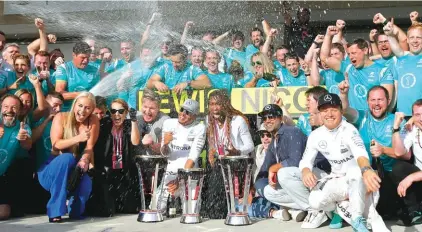  ??  ?? Mercedes driver Lewis Hamilton, of Britain, and Mercedes driver Nico Rosberg, of Germany, celebrate with the crew and friends at the end of the US GP Photo: AP