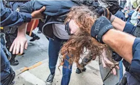  ?? ALTON STRUPP/USA TODAY NETWORK ?? Louisville police officers pull a protester out of a crowd reacting to a grand jury announceme­nt Wednesday.