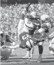  ?? Ron Jenkins / Associated Press ?? TCU running back Sewo Olonilua (33) dives over the goal line to score a touchdown against West Virginia in the second quarter Saturday at Fort Worth.