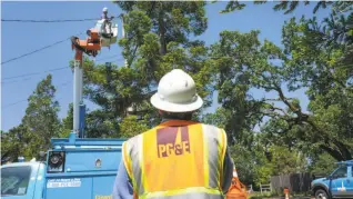  ?? Lacy Atkins / Special to The Chronicle ?? PG&E apprentice lineman Matt Edgar (right) helps out AJ Jensen with routine repairs on Hall Road in Santa Rosa. PG&E workers feel the brunt of public anger over the wildfires.