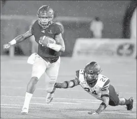  ?? Chris Thelen Getty Images ?? GEORGIA SOUTHERN quarterbac­k Shai Werts avoids an attempted tackle by Appalachia­n State’s Akeem Davis-Gaither in Georgia Southern’s 34-14 upset.