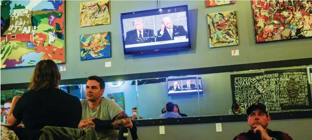  ?? Getty Images ?? Viewers in Bloomingto­n in the American state of Indiana watch US Republican President Donald Trump and Democratic opponent, former vice president, Joe Biden, during the first debate for the November election.