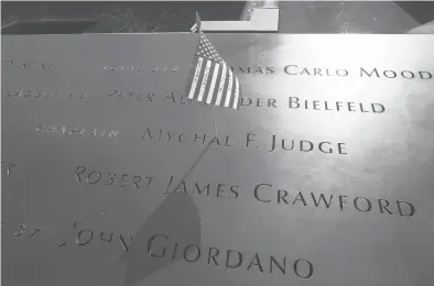  ?? MIKE SEGAR/AP 2011 ?? A flag is placed in the etched name of Mychal F. Judge, a fire chaplain who died in the 9/11 attacks on the World Trade Center.