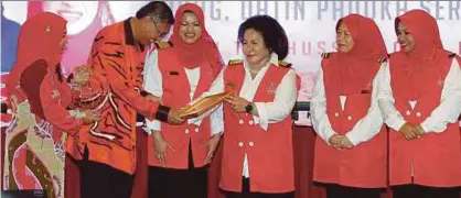  ?? [FOTO NURUL SYAZANA ROSE RAZMAN/BH] ?? Rosmah menyampaik­an Anugerah Khas Skuad Sayang 2017 kepada Ahli Majlis Tertinggi UMNO merangkap Pengerusi Biro Kebajikan UMNO, Datuk Dr Shamsul Anuar Nasarah pada majlis tahunan bersama Penaung Skuad Sayang Kebangsaan 2017, di PWTC, semalam.