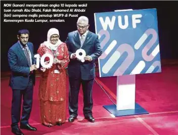  ?? FOTO: ?? NOH (kanan) menyerahka­n angka 10 kepada wakil tuan rumah Abu Dhabi, Falah Mohamed Al Ahbabi (kiri) sempena majlis penutup WUF9 di Pusat Konvensyen Kuala Lumpur, semalam.
