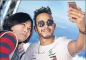  ?? AFP ?? Mercedes driver Lewis Hamilton takes a selfie with a fan ahead of the Australian Grand Prix in Melbourne on Thursday.