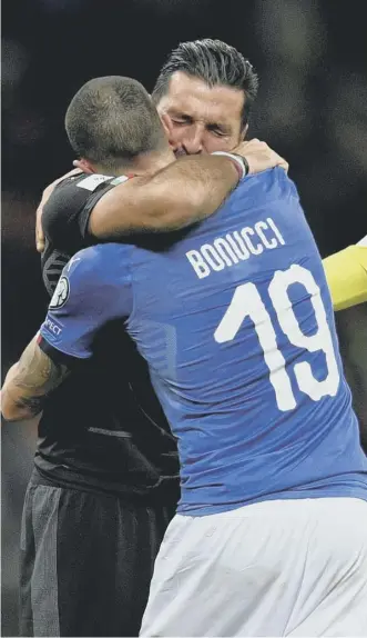  ??  ?? 0 Italy captain Gianluigi Buffon and defender Leonardo Bonucci console each other.