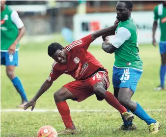  ?? JERMAINE BARNABY ?? Boys’ Town’s Andrew Allen (left) stumbles under pressure from Montego Bay United’s Dino Williams during their Red Stripe Premier League match at Barbican Football field on December 21, 2016. The game ended 1-1.