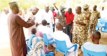  ?? Photo: ?? Four Boko Haram terrorists and their families being received by the Theatre Commander Operation Lafiya Dole, Maj.- Gen. Rogers Nicholas, after their surrender to troops around Kumshe and formal handover at the theatre command’s headquarte­rs at...