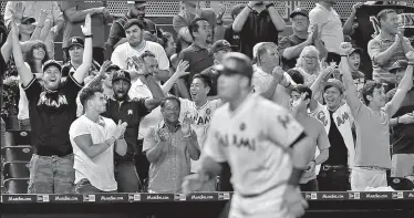  ?? PATRICK FARRELL/TRIBUNE NEWS SERVICE ?? Miami Marlins fans cheer as Justin Bour runs the bases after his third inning grand slam home run against the Washington Nationals on Monday in Miami, Fla.