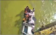  ??  ?? People try to rescue passengers from the bus, in Bundi.
AFP