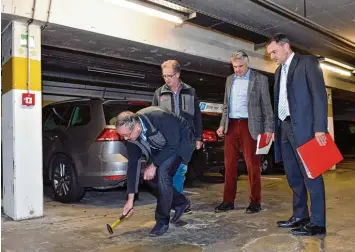  ?? Fotos: Thorsten Jordan ?? In den Böden der Schlossber­ggarage haben sich durch Korrosion bereits Hohlräume gebildet, wie Oskar Imhof beim Ortstermin mit Günter Schmid, Norbert Köhler (alle Stadtwerke) und OB Mathias Neuner vorführt.