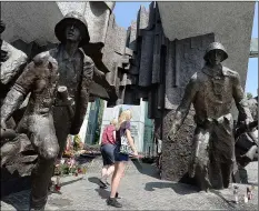  ??  ?? Warsaw residents stop by the monument to the 1944 Warsaw Rising against the occupying Nazis in memory of some 18,000 resistance fighters who fell in the struggle against the German forces and some 180,000 civilians who perished 74 years ago, in Warsaw,...