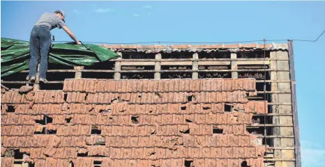  ?? FOTO: M. MURAT/DPA ?? Stürme können an Hausdächer­n schwere Schäden anrichten. Eine Wohngebäud­eversicher­ung kommt in der Regel für die Kosten auf.