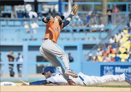  ?? Photograph­s by John McCoy Getty Images ?? THE DODGERS’ Cody Bellinger steals second base before the Astros’ Marwin Gonzalez is able to apply the tag. The Dodgers, who have played 17 days in a row since the All-Star break, going 9-8, avoided a three-game sweep by the World Series champions.