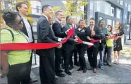  ??  ?? MAYOR ERIC GARCETTI, center, joins political leaders and homeless outreach workers at the grand opening of the new apartment buildings.